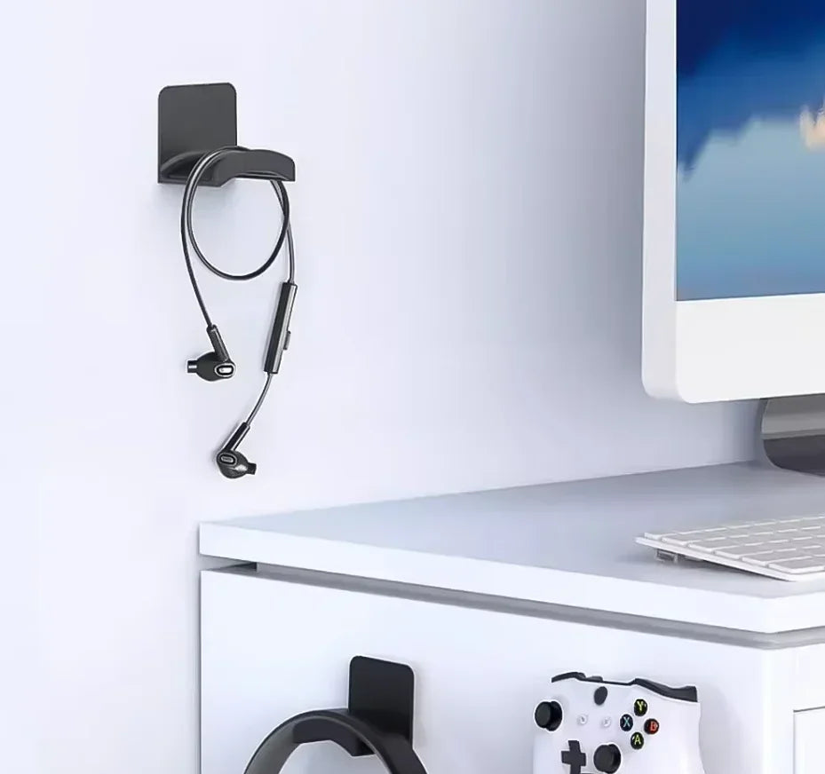 Black adhesive headphone hook mounted beside a desk
