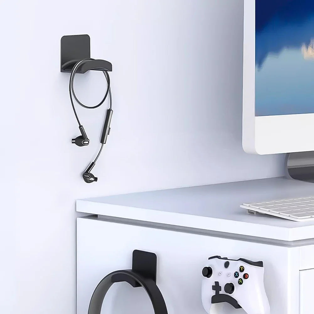 Black HookDock adhesive headphone hook holding headphones under a desk