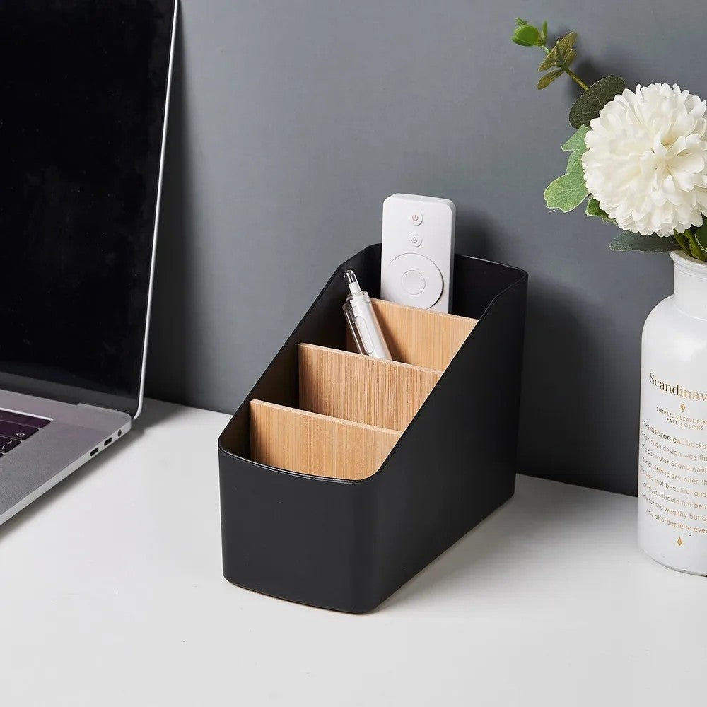 RemoteNest black desktop remote organizer beside a TV