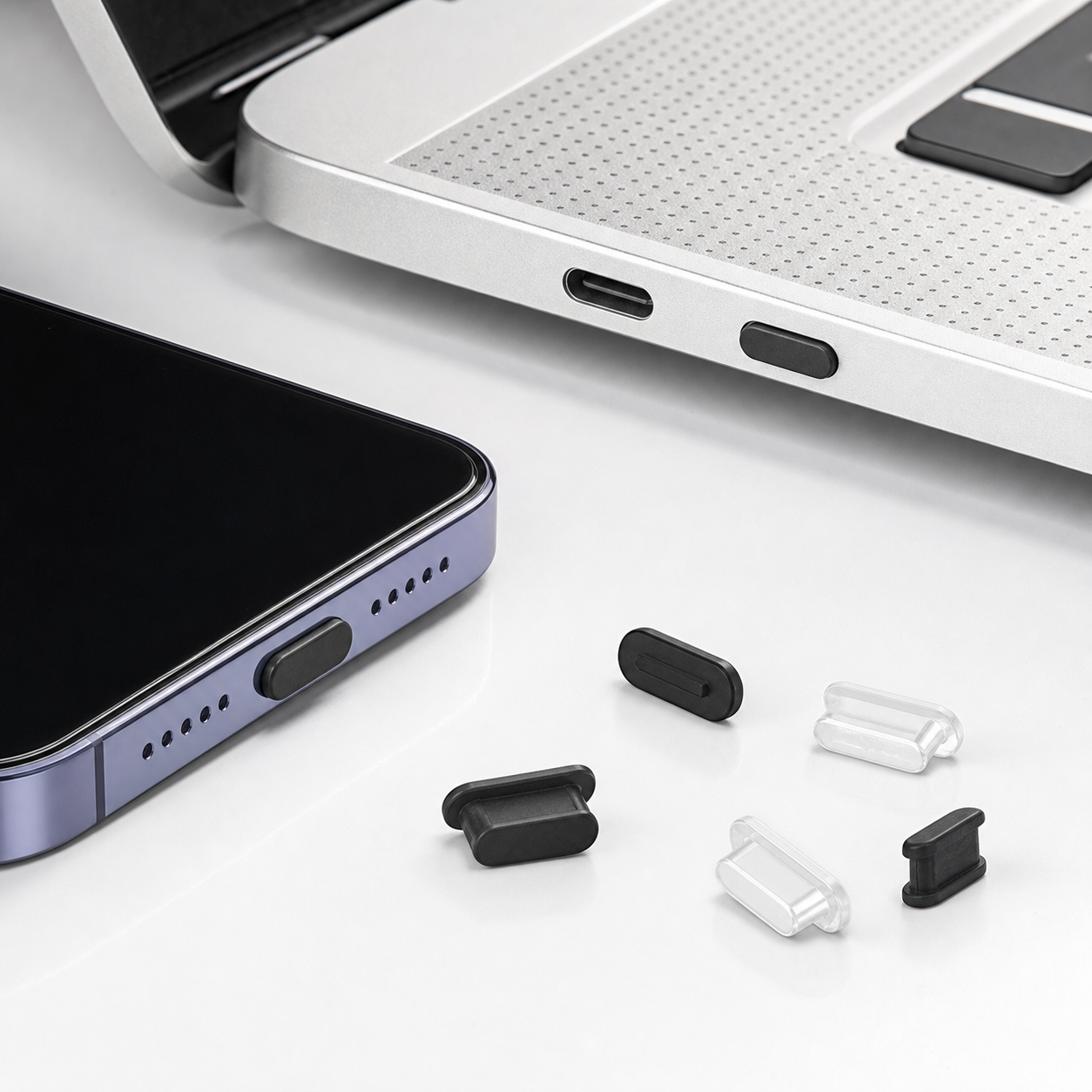 DustGuard USB-C port covers shown with a laptop and phone for scale