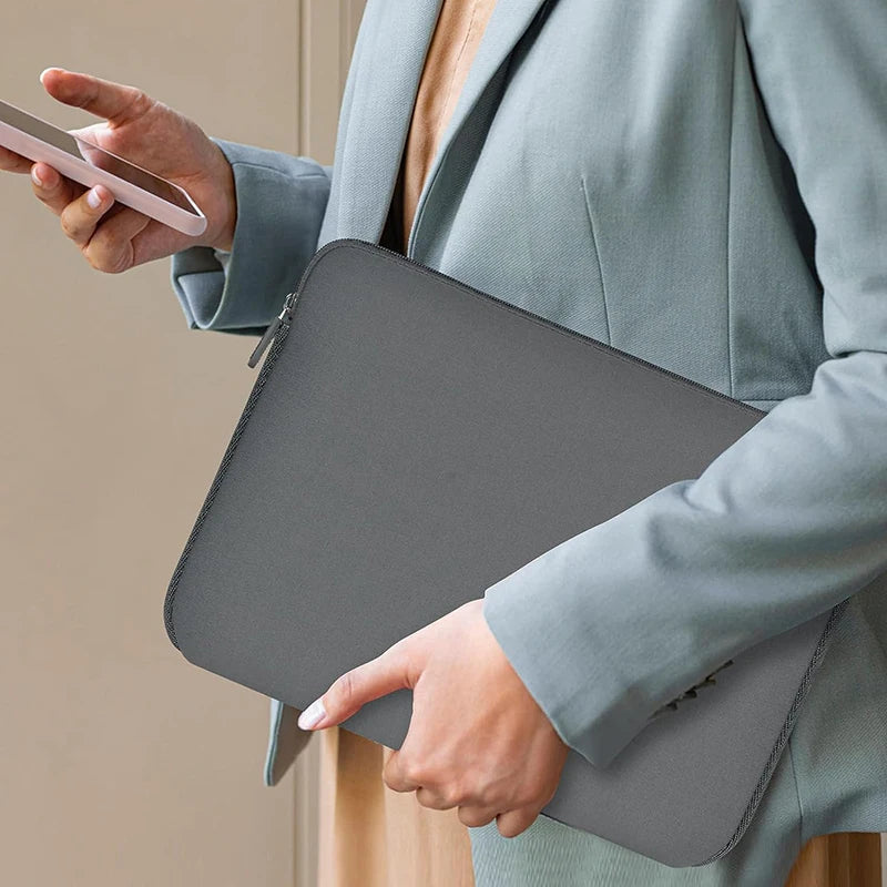 MonoCase grey laptop sleeve carried by hand lifestyle image